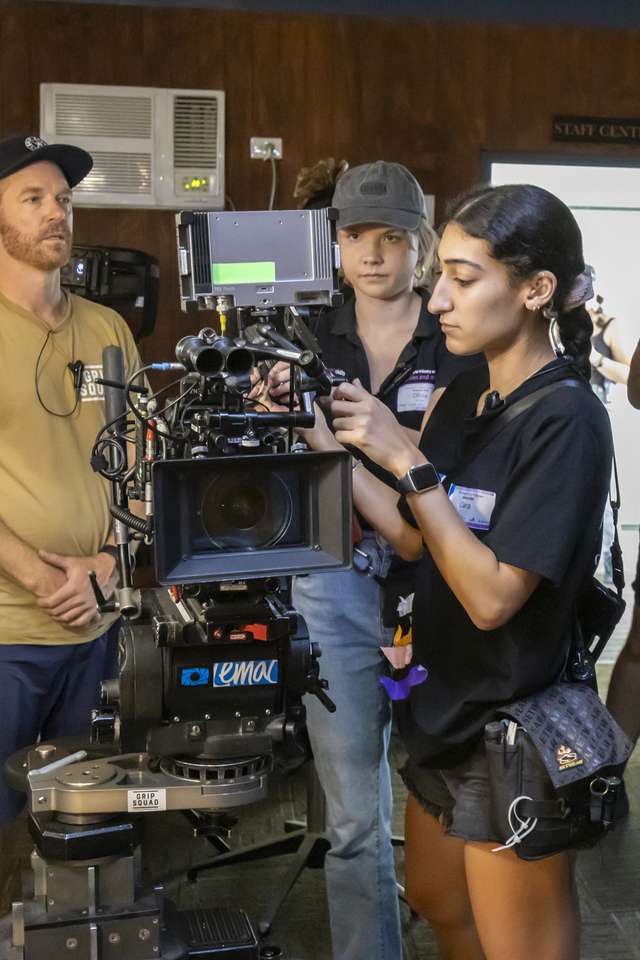 People gathered around a film camera