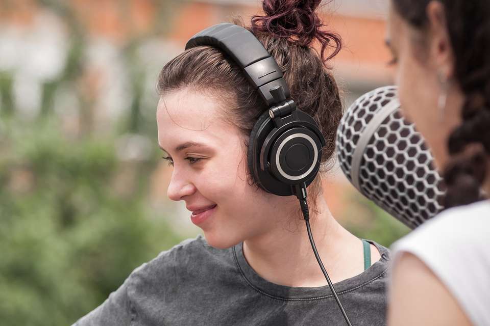 Women wearing headphones looking off camera to her right