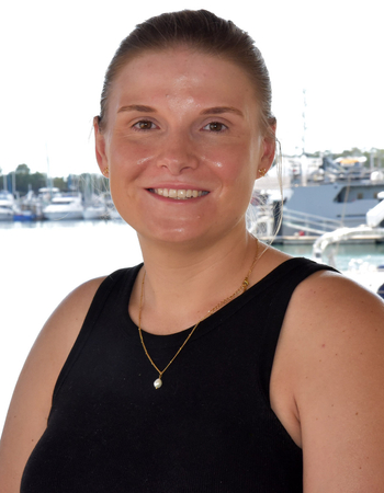 Headshot of Dr Grace Blackburn smiling with Gladstone Harbour in the background