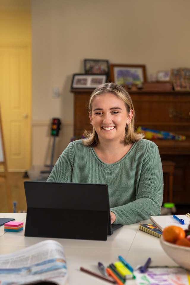 A woman studying at home on tablet computer in her family home.