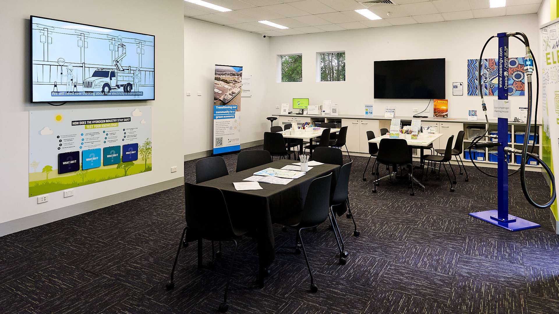 Hydrogen Central room with desks, TVs, scolourful resources and posters and a hydrogen pump