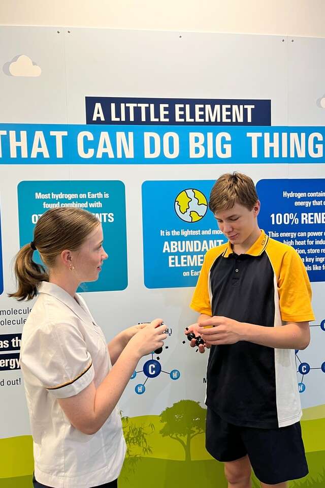 Two students in uniforms facing each other while talking.