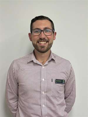 Jarrod McGuinness smiling at camera with hands behind his back.