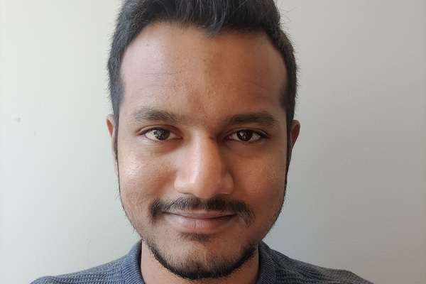 Jaswanth Valupadasu smiling with a grey background