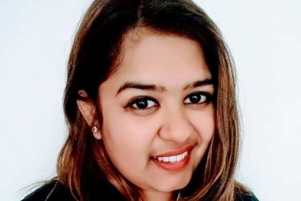 Jayita Nandi, student from Nepal, smiling in front of a white background