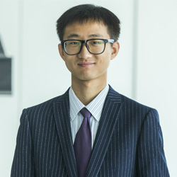 Jingduan Li smiling at the camera in a business suit