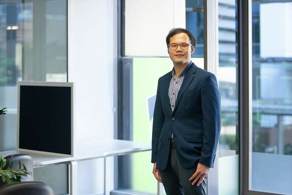 International student Lin Myat Aung from Myanmar wearing a suit and glasses.