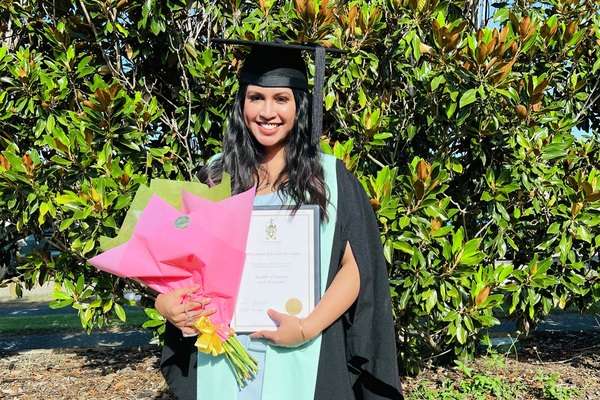 Marie Loraine holding her diploma and flowers