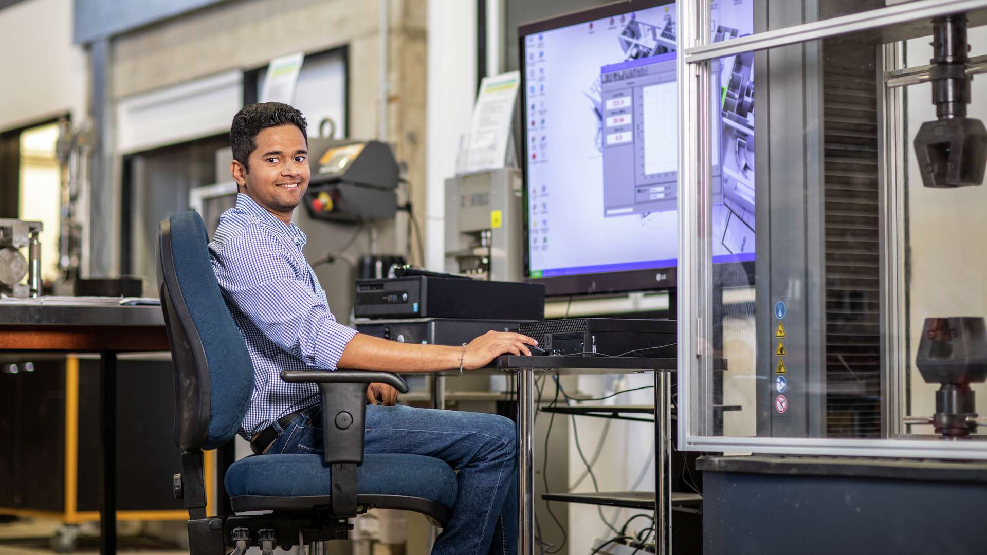 Man sitting at a computer in an engineering research lab
