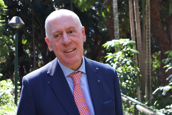 Chancellor, Graeme Innes standing on the Rockhampton campus smiling at the camera