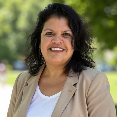 Heatshot of Dr Michelle Vanderburg wearing a white shirt and tan coloured jacket smiling at the camera