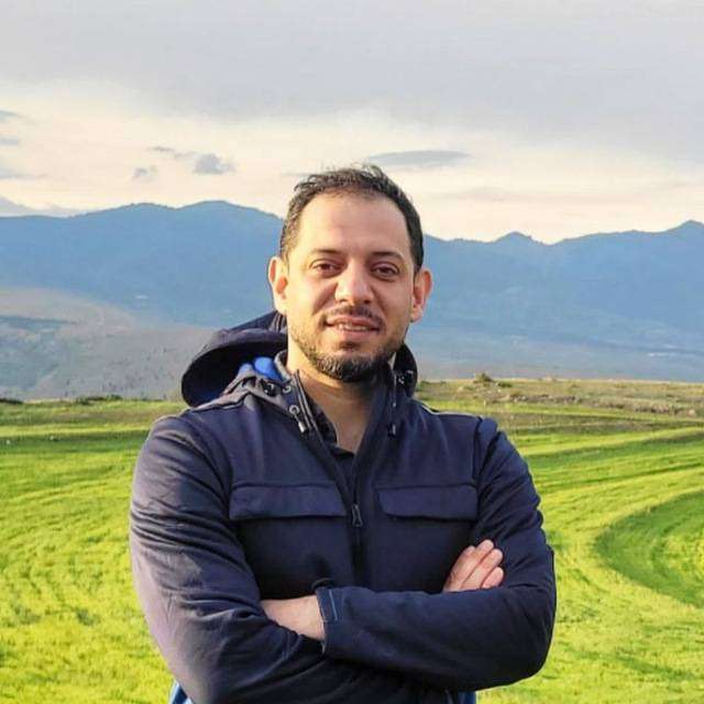 Milad Alizadeh Galdiani standing with arms crossed on a grassy field
