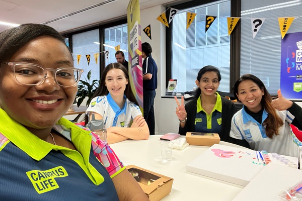 Selfie of four Mindwave Connector students smiling and sitting around a morning tea table