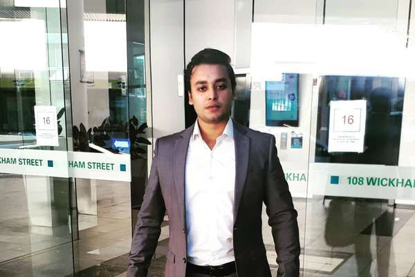 Muhammad Ahsan Ahmed standing in front of a office building