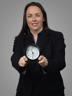 Professor Grace Vincent holding a clock in front of her