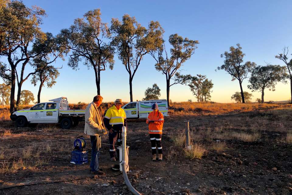 Three people in Hi-Vis standing in an outback setting