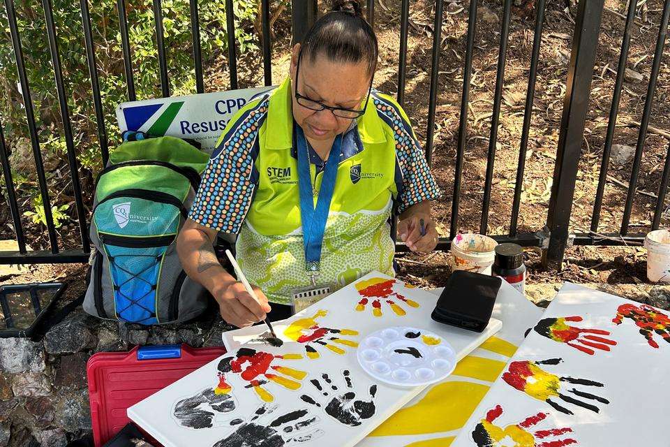 Woman painting Indigenous handprints