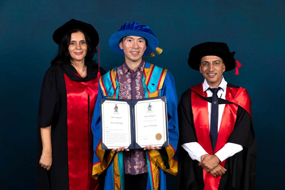 Three people standing in regalia