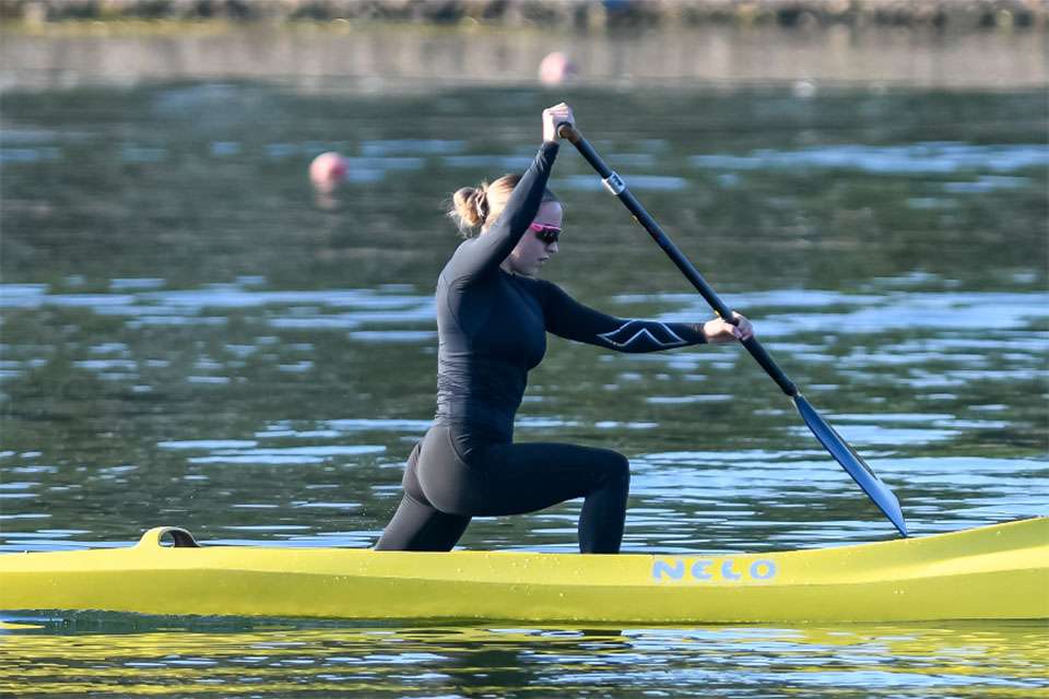 Women in wetsuit and sunglasses paddling canoe