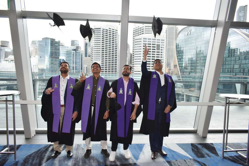 Sydney graduates throwing their caps in celebration