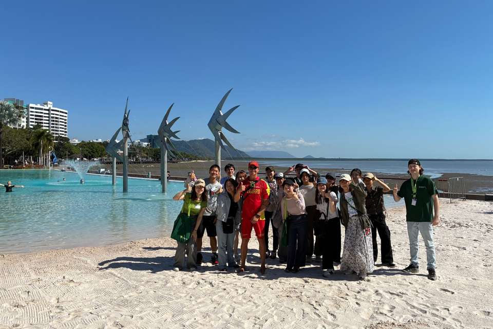 Group of students standing on a beach with a lifeguard