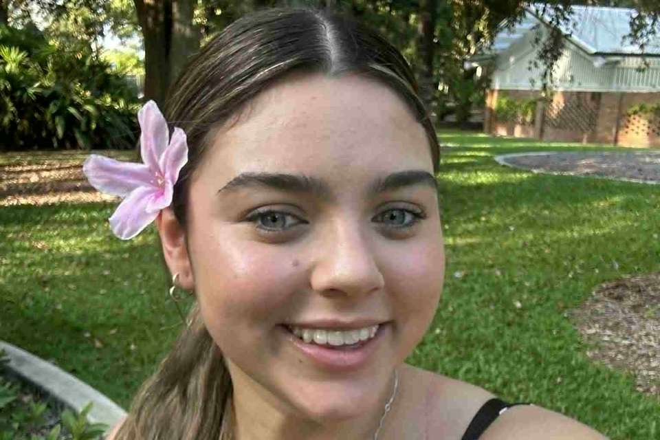 Woman in spotted dress with flower behind ear
