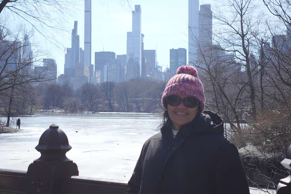 Woman in cold weather attire standing in front of city scape