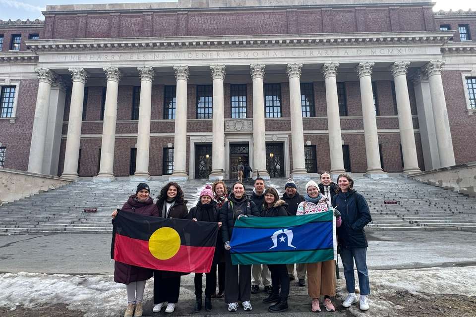 Group of people standing on stairs holding two flags