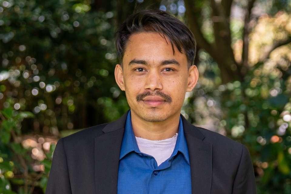 Man in blue button up shirt and black jacket