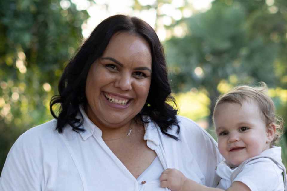 Women in a white dress holding a baby