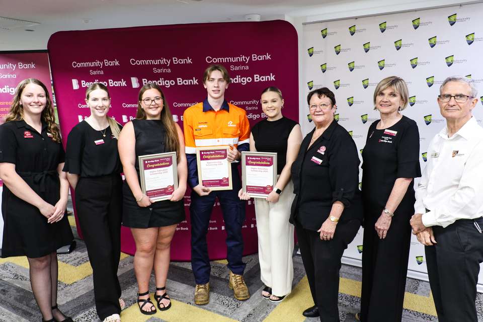 Group of people standing in front of Community Bank Sarina and CQUniversity banners
