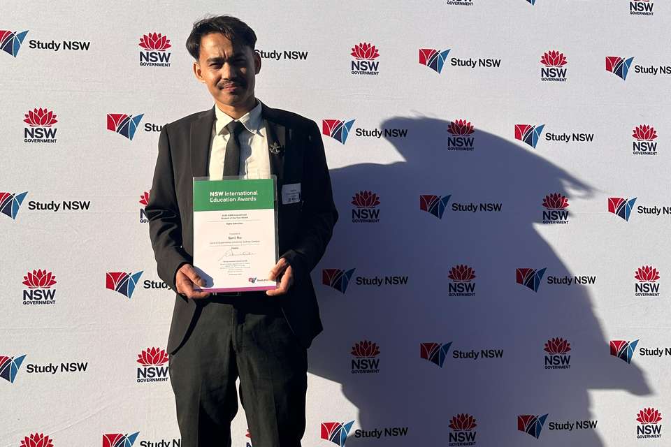 Man in a suite holding a certificate