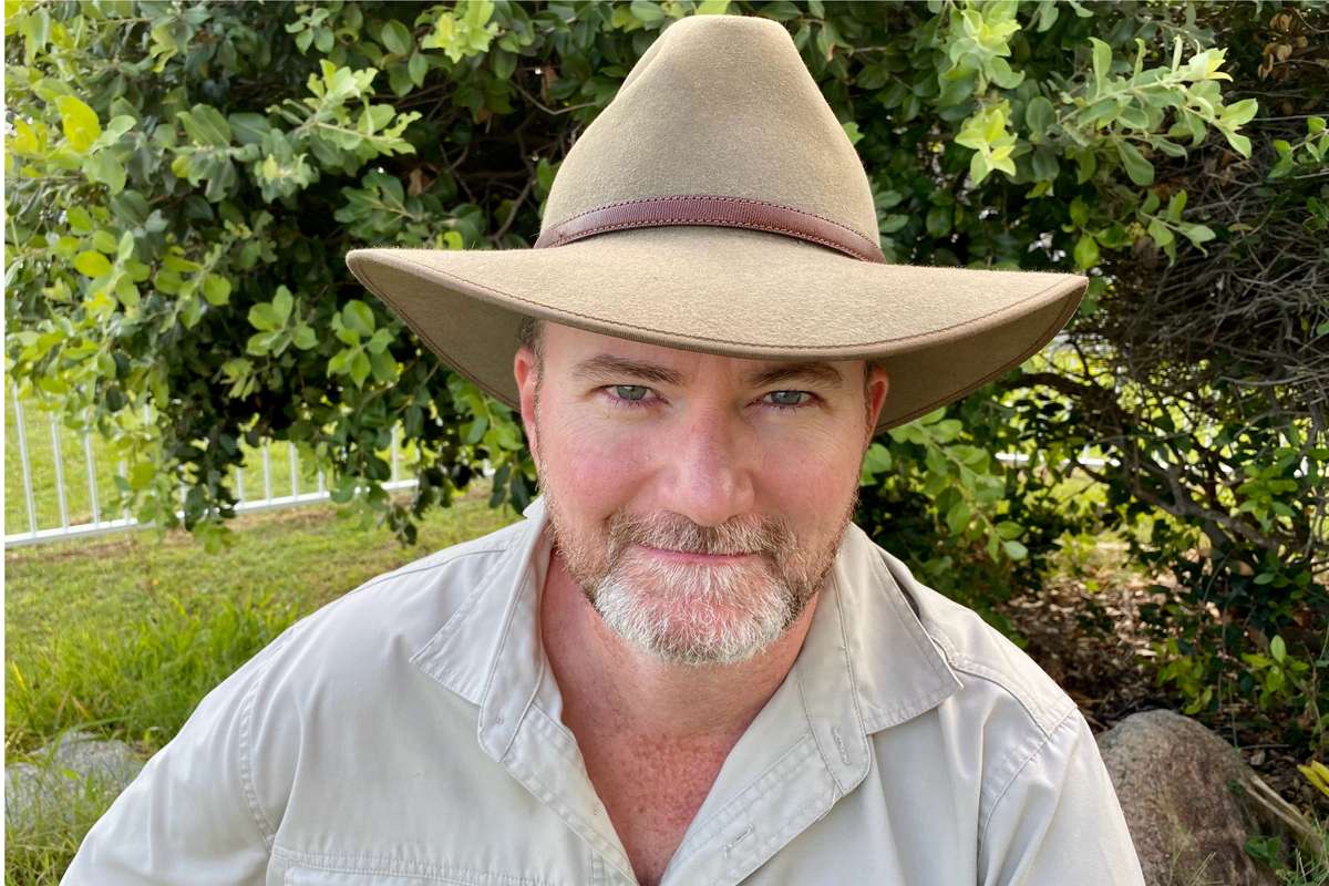 Man smiling while wearing a brown hat