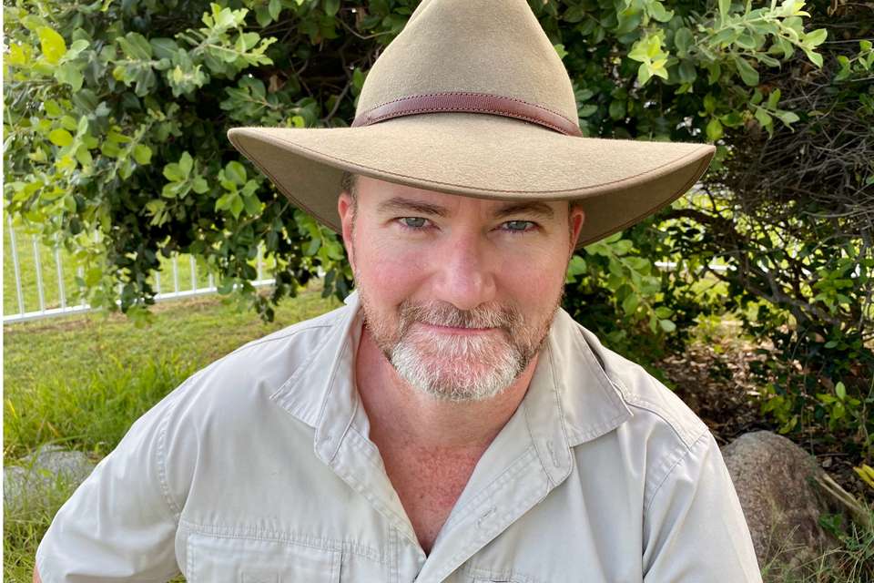 Man smiling while wearing a brown hat