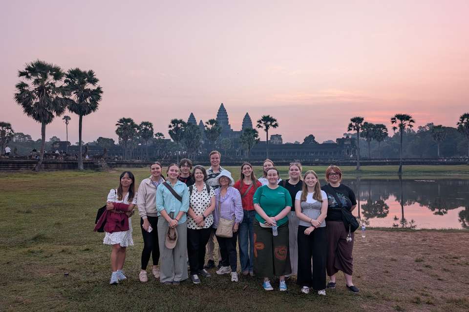 Group of people standing in front of Angkor Wat temple