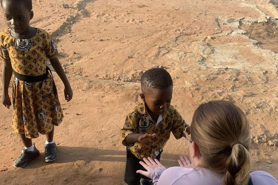 Woman with crouching down next to young child.