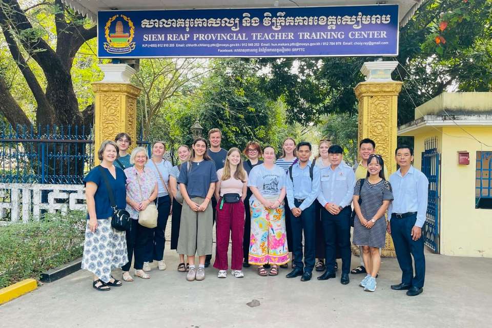Group of people standing in front of a sign