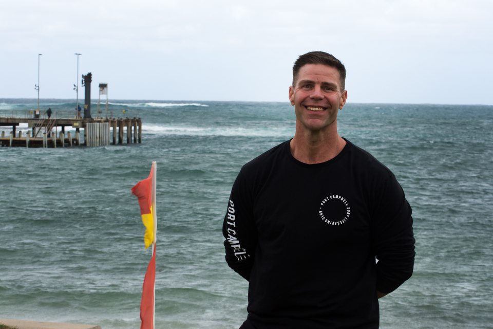 Man in black shirt standing on the beach