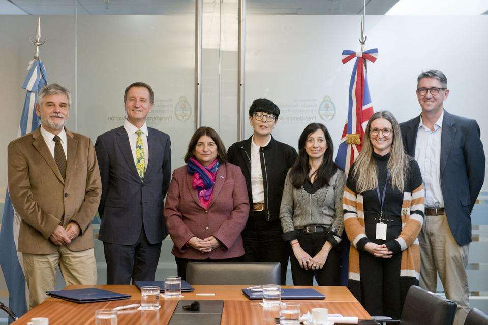 A group of seven people including Professor Nick Klomp, are looking at the camera and stand alongside a timber boardroom table following the signing of a research MOU between CQUniversity and Argentina’s Ministry of Science and Technology (MINCYT) and the National Council for Scientific and Technical Research (CONICET).