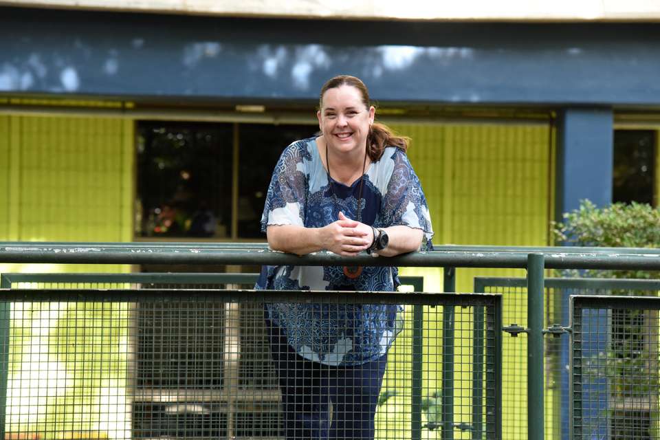 Anne-Maree Scott looks over bridge in front of building.jpg