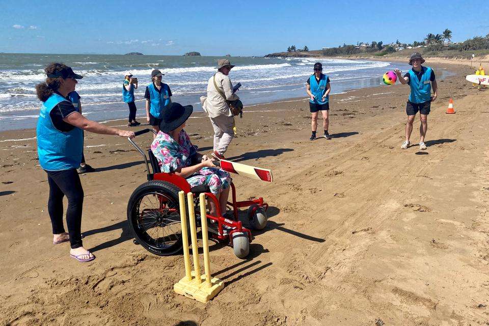 CQU Physiotherapy students playing beach cricket with an elderly woman in her beach wheelchair.jpg