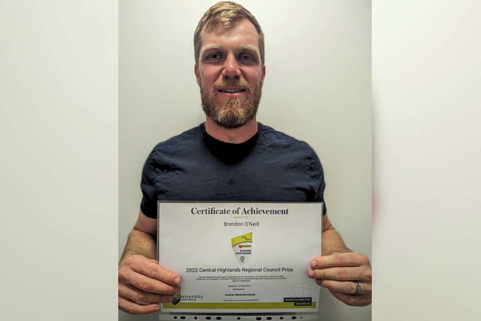 Photo of man with beard holding certificate