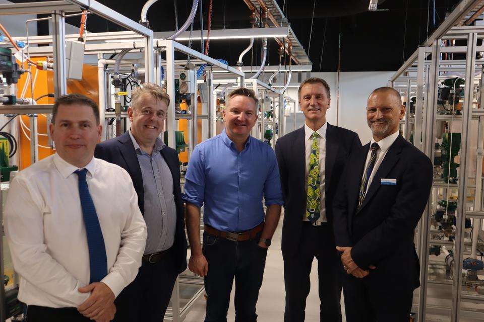 Five men stand in a hydrogen workshop