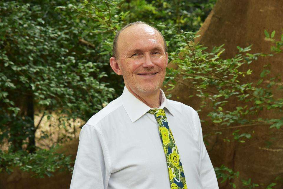 Dean of the School of Education and the Arts, Professor Stephan Dobson standing in front of greenery smiling at the camera