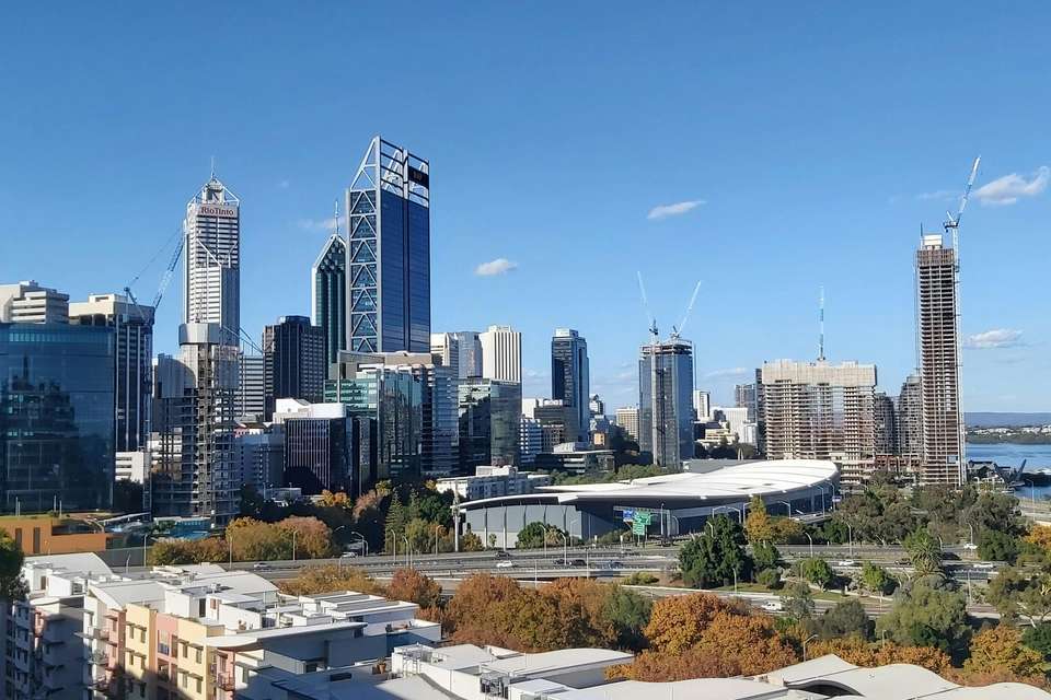 A wide scoping shot of the city of Perth, featuring skyscrapers, parks and waterway