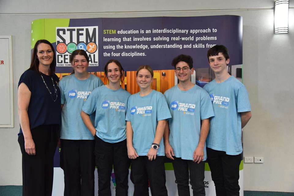 The Faith Baptist Christian College teacher and four students stand in front of the Gladstone STEM Central banner and smile ahead of their trip to Las Vegas to participate in the H2GP world finals.