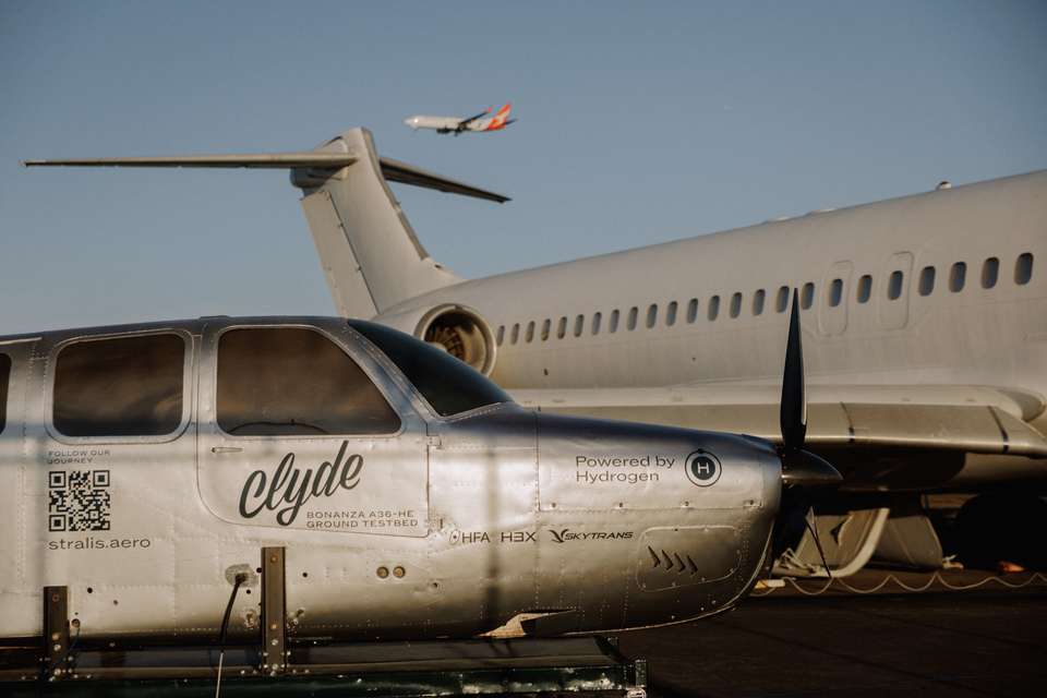 Hydrogen-test-plane-on-air-strip-with-qantas-plane-in-the-air.jpg