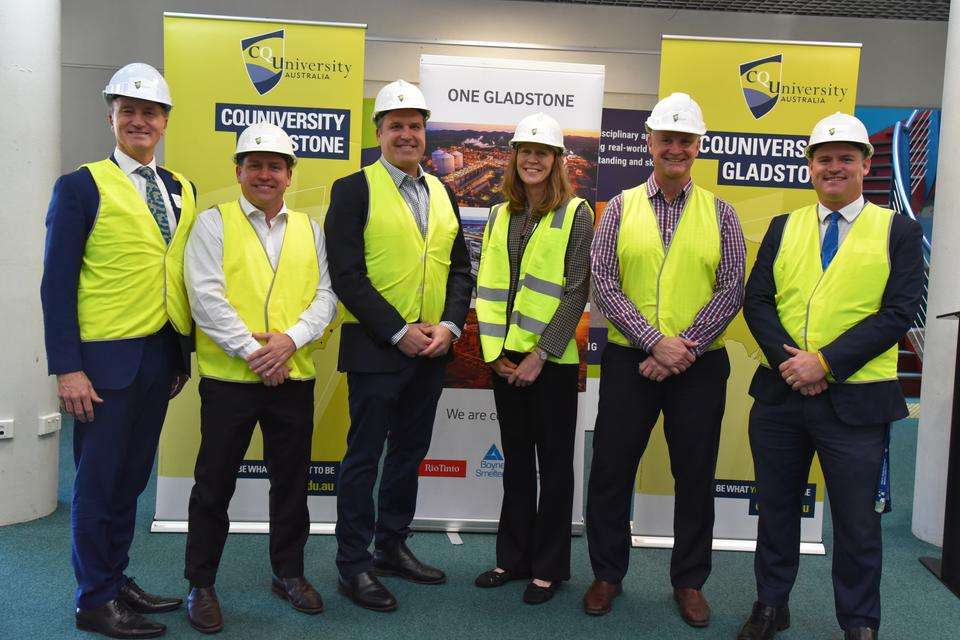 CQU Vice-Chancellor and President Professor Nick Klomp, Mayor Matt Burnett, Tim McDougall (Rio Tinto), Dr Cal Devney, Glen Butcher MP, CQU Associate Vice-President (Gladstone and Wide Bay) Luke Sinclair stand in front of Corporate Banners wearing hi-vis and hard hats