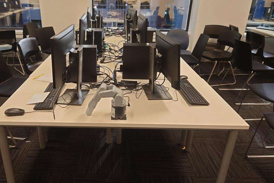 A bank of desktop computers line either side of a central desk.