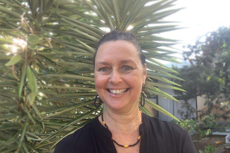 A headshot of CQU alumna Kerry Staines against a garden backdrop of native plants